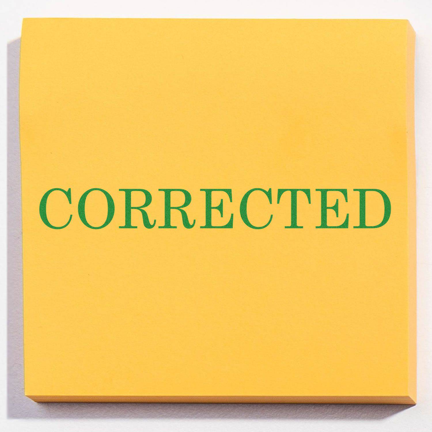 Yellow paper stamped with CORRECTED in green ink using the Large Pre-Inked Corrected Stamp.