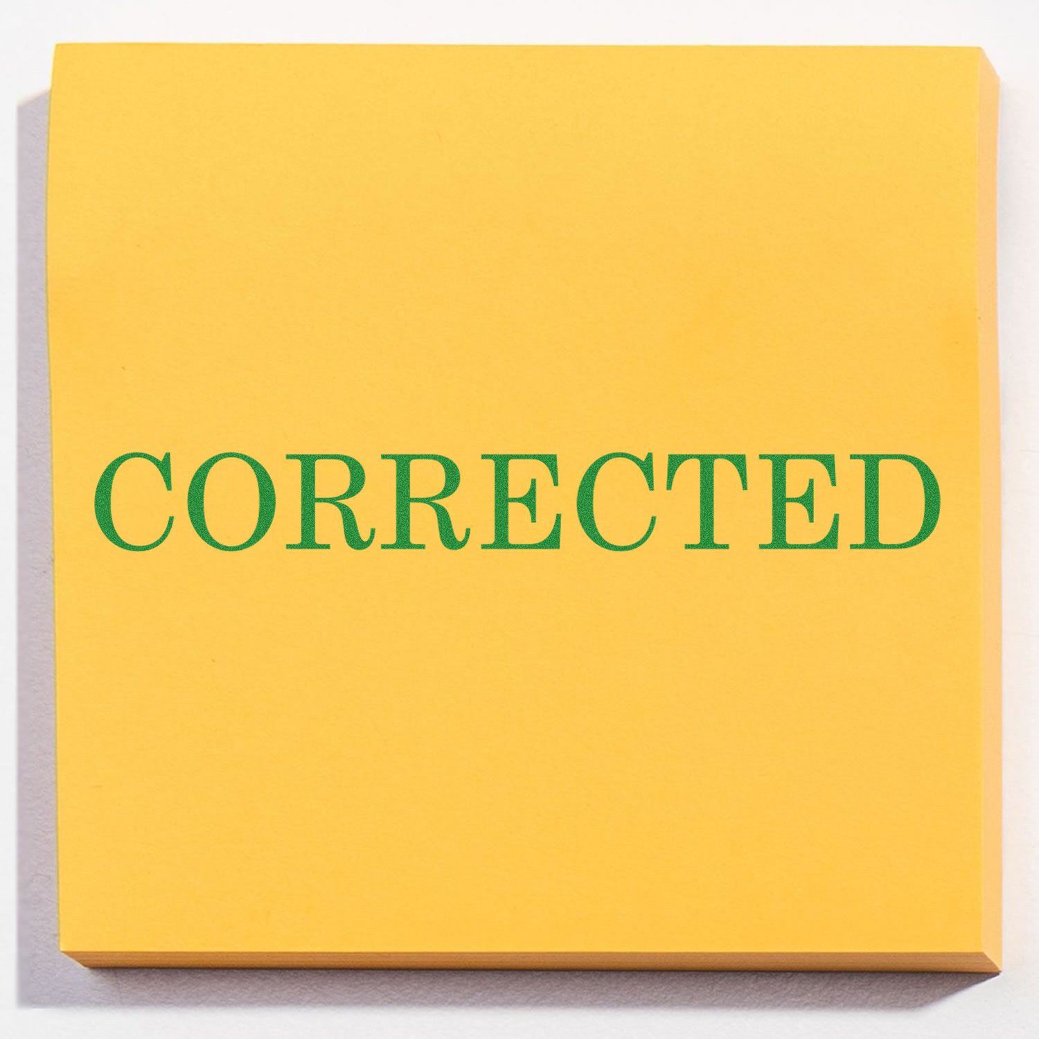 Yellow paper stamped with CORRECTED in green ink using the Self Inking Corrected Stamp.