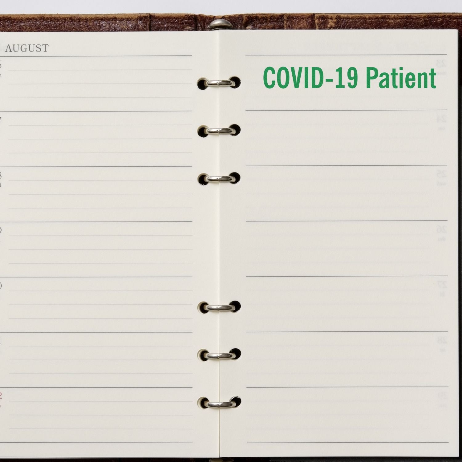 Open planner with COVID-19 Patient stamped in green ink on the right page using a Slim Pre-Inked Covid-19 Patient Stamp.
