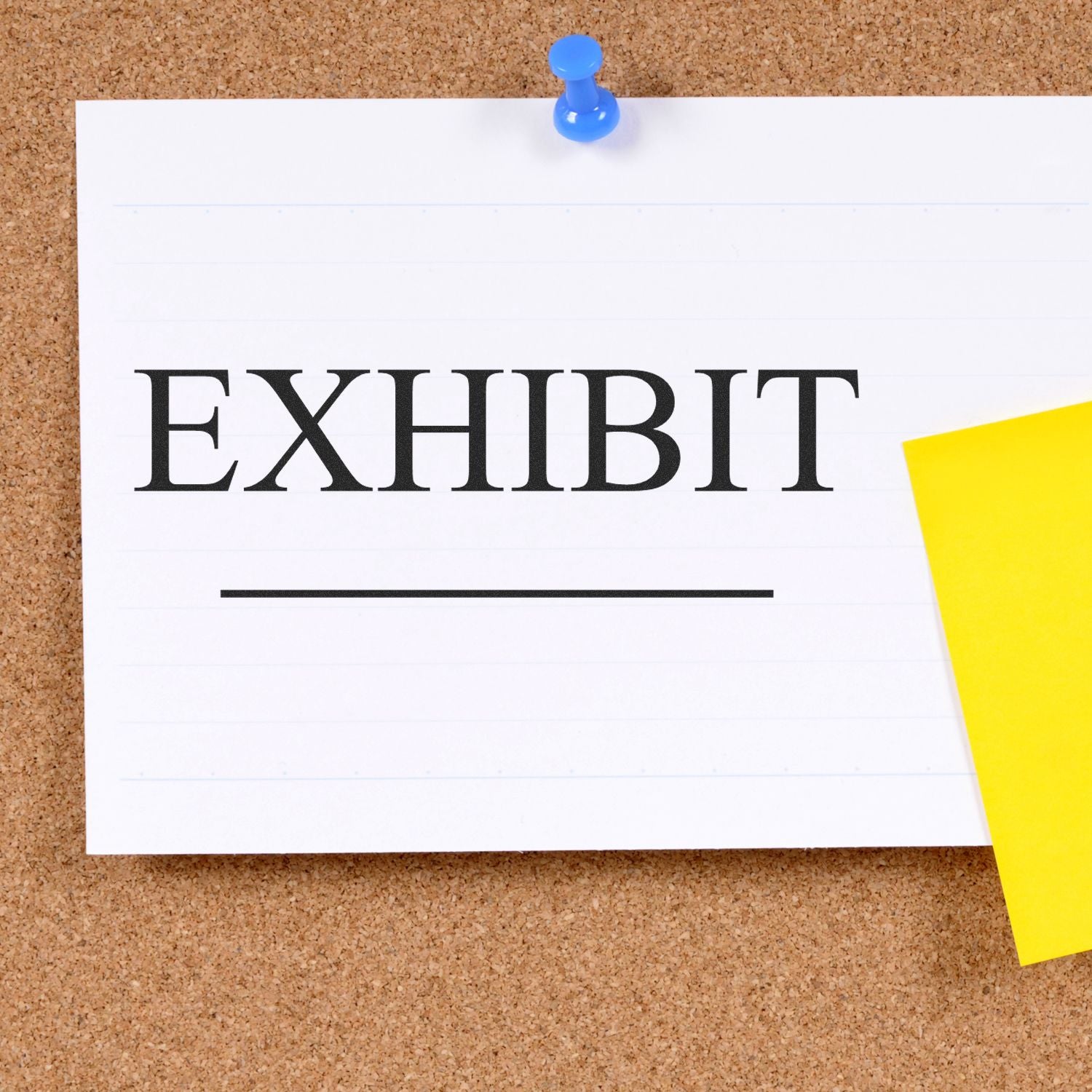 Self Inking Exhibit Stamp used on a white card pinned to a corkboard with a blue pushpin and a yellow sticky note beside it.