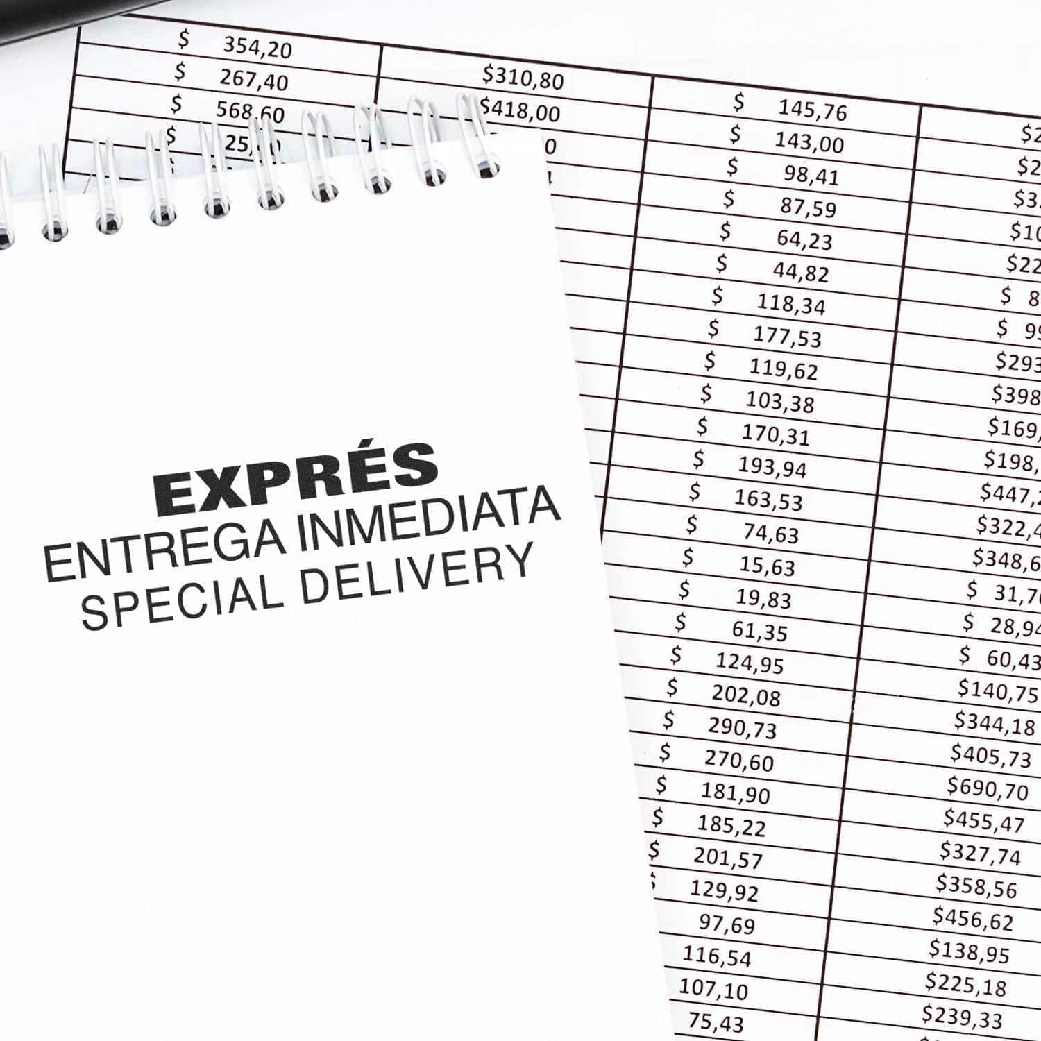 Large Pre-Inked Expres Entrega Inmediata Stamp used on a notepad, placed next to a financial spreadsheet.