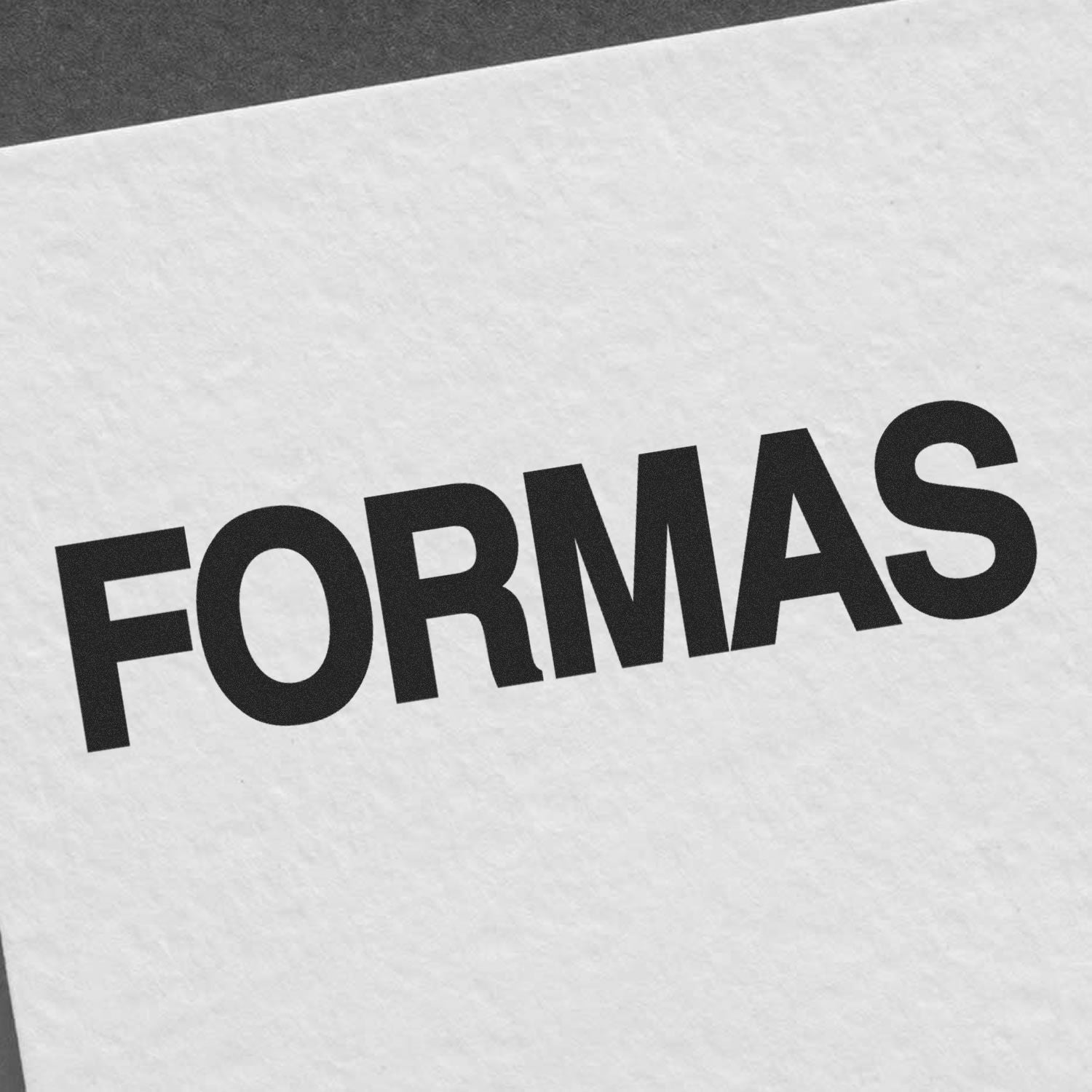Large Formas Rubber Stamp imprinting the word FORMAS in bold black letters on a textured white paper.