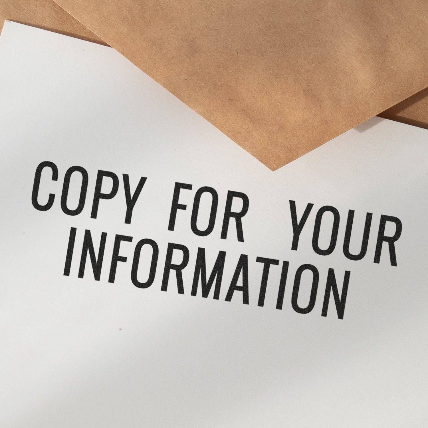 Large Pre-Inked Narrow Copy for your Information Stamp used on white paper, with brown envelopes in the background.