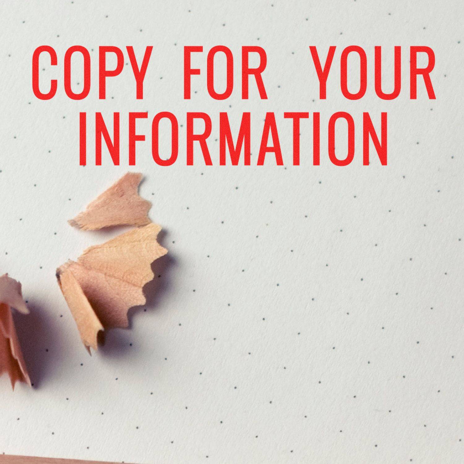 Large Pre-Inked Narrow Copy for your Information Stamp in red ink on dotted paper with pencil shavings nearby.