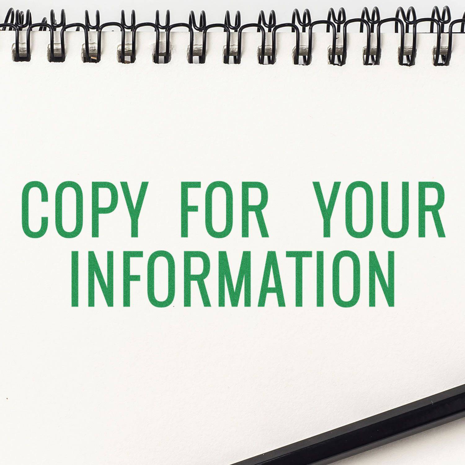 Large Pre-Inked Narrow Copy for your Information Stamp in green ink on a white notepad with a black pen at the bottom right corner.
