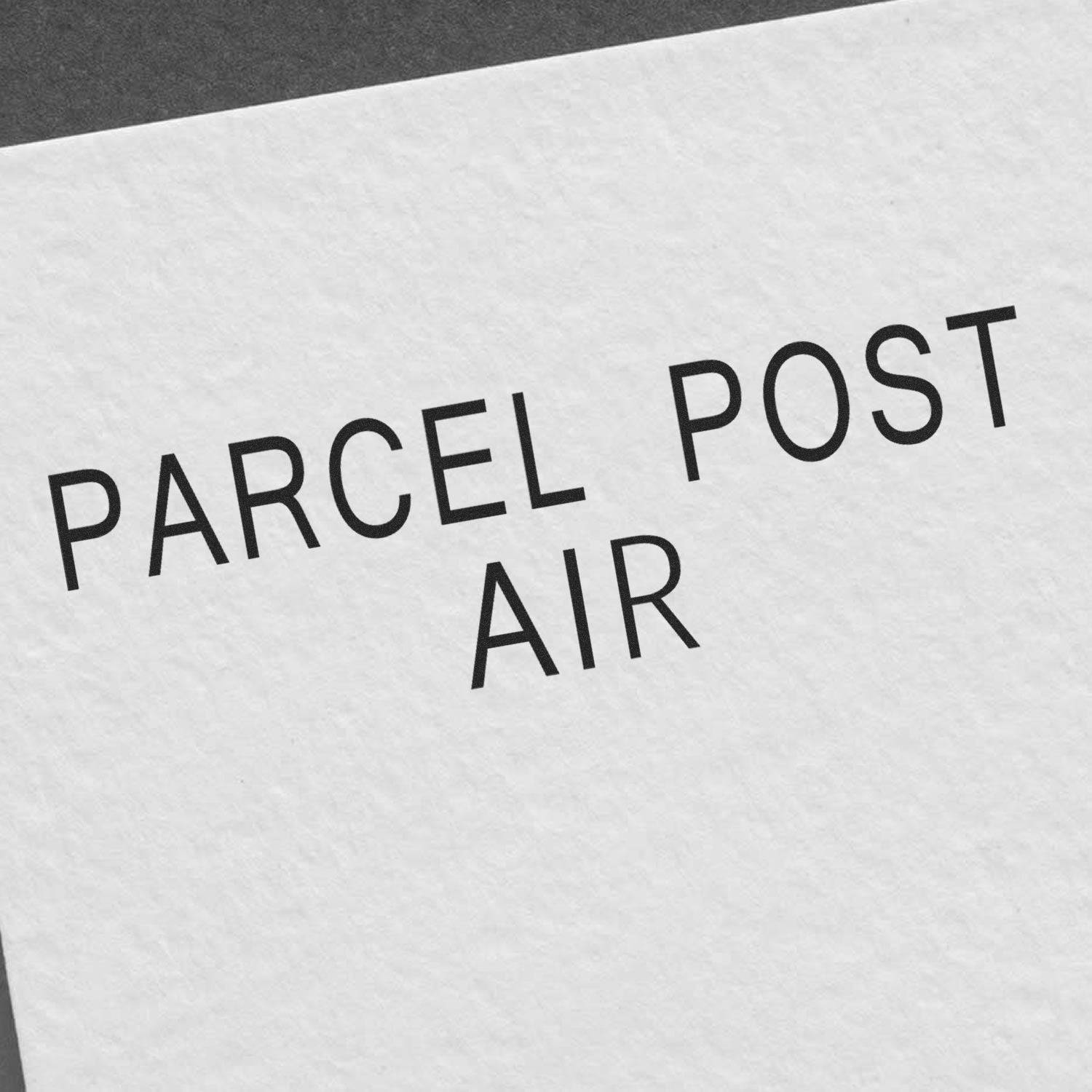 Large Parcel Post Air Rubber Stamp in use, showing clear, bold text PARCEL POST AIR on white paper.