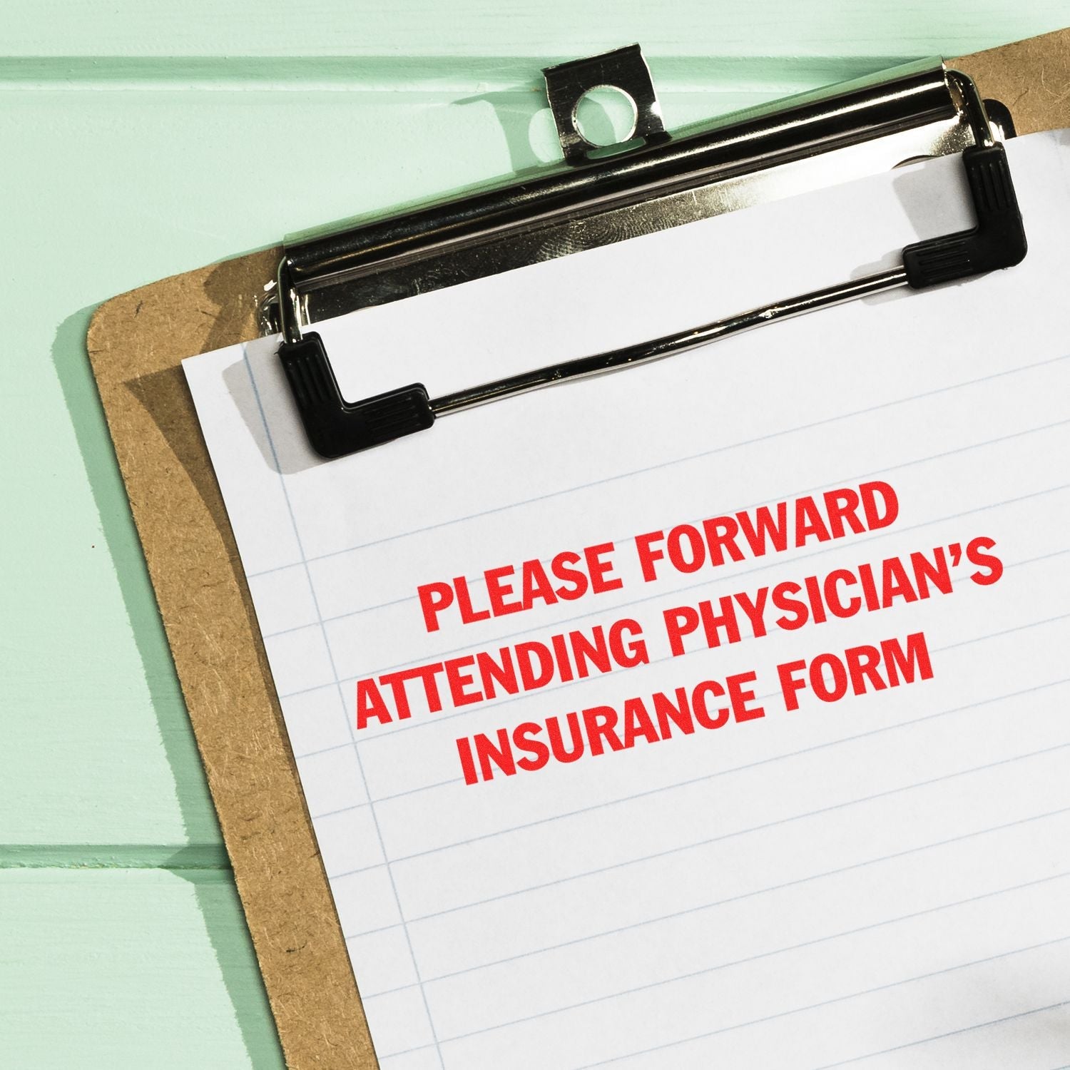 Clipboard with paper stamped in red ink using the Self Inking Please Forward Insurance Form Stamp, reading PLEASE FORWARD ATTENDING PHYSICIAN'S INSURANCE FORM.