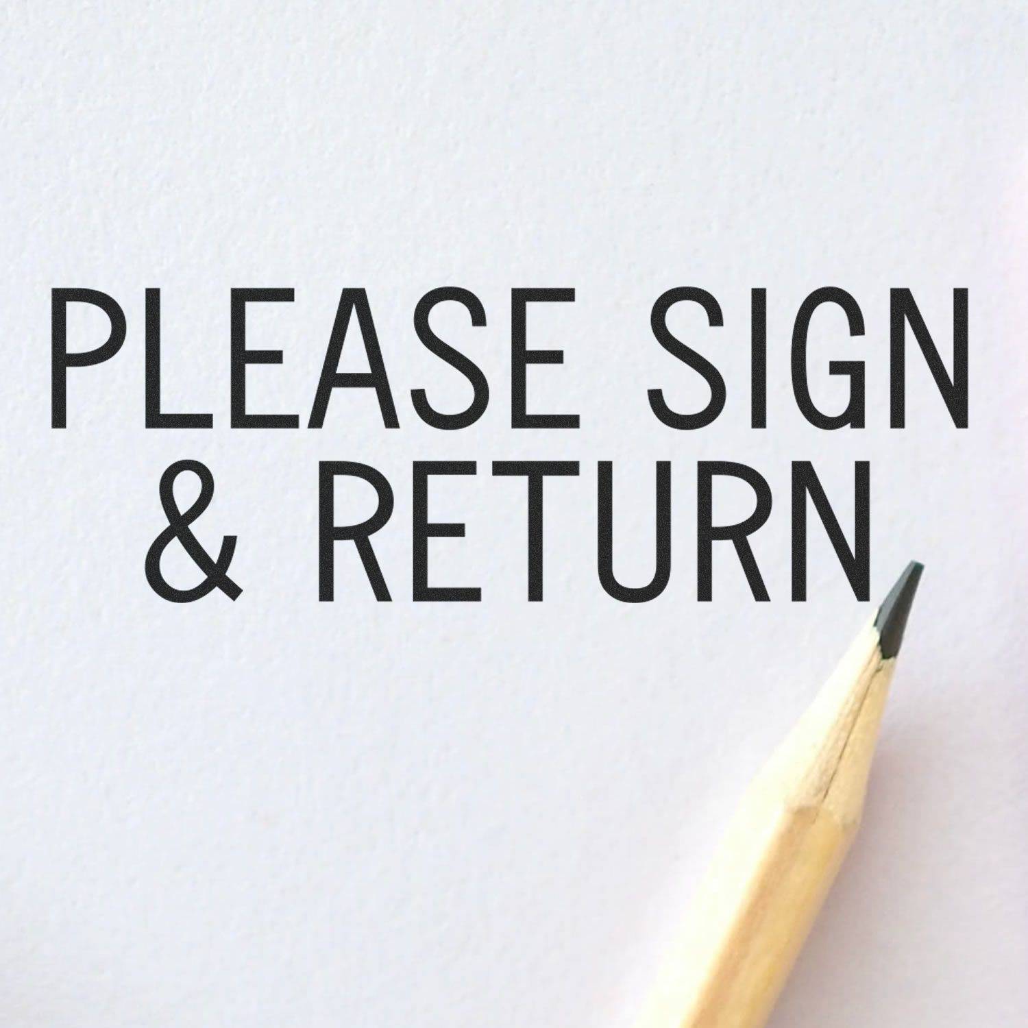Large Please Sign & Return Rubber Stamp impression on white paper with a pencil tip visible in the corner.
