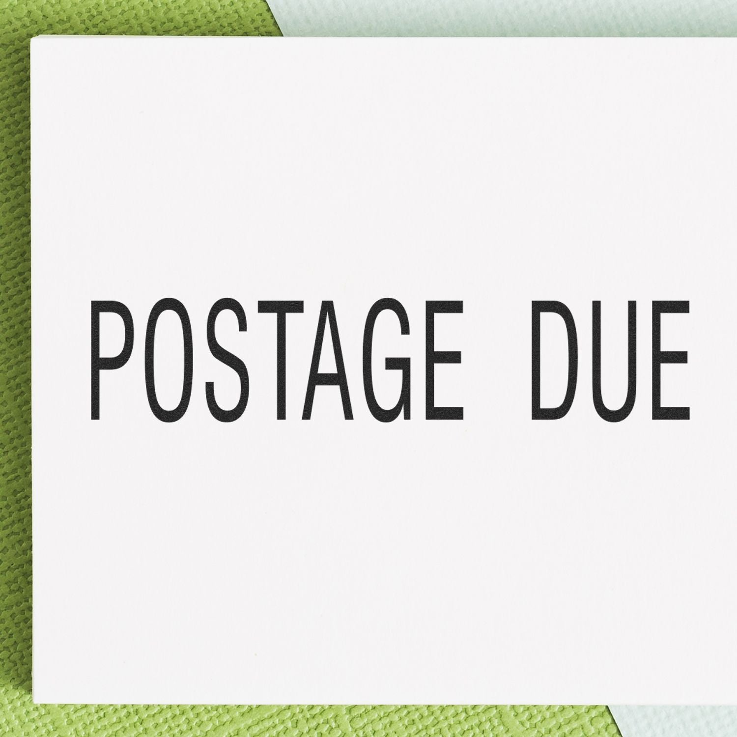 Large Self Inking Postage Due Stamp in use, showing the clear and bold POSTAGE DUE text on a white background with a green textured surface.