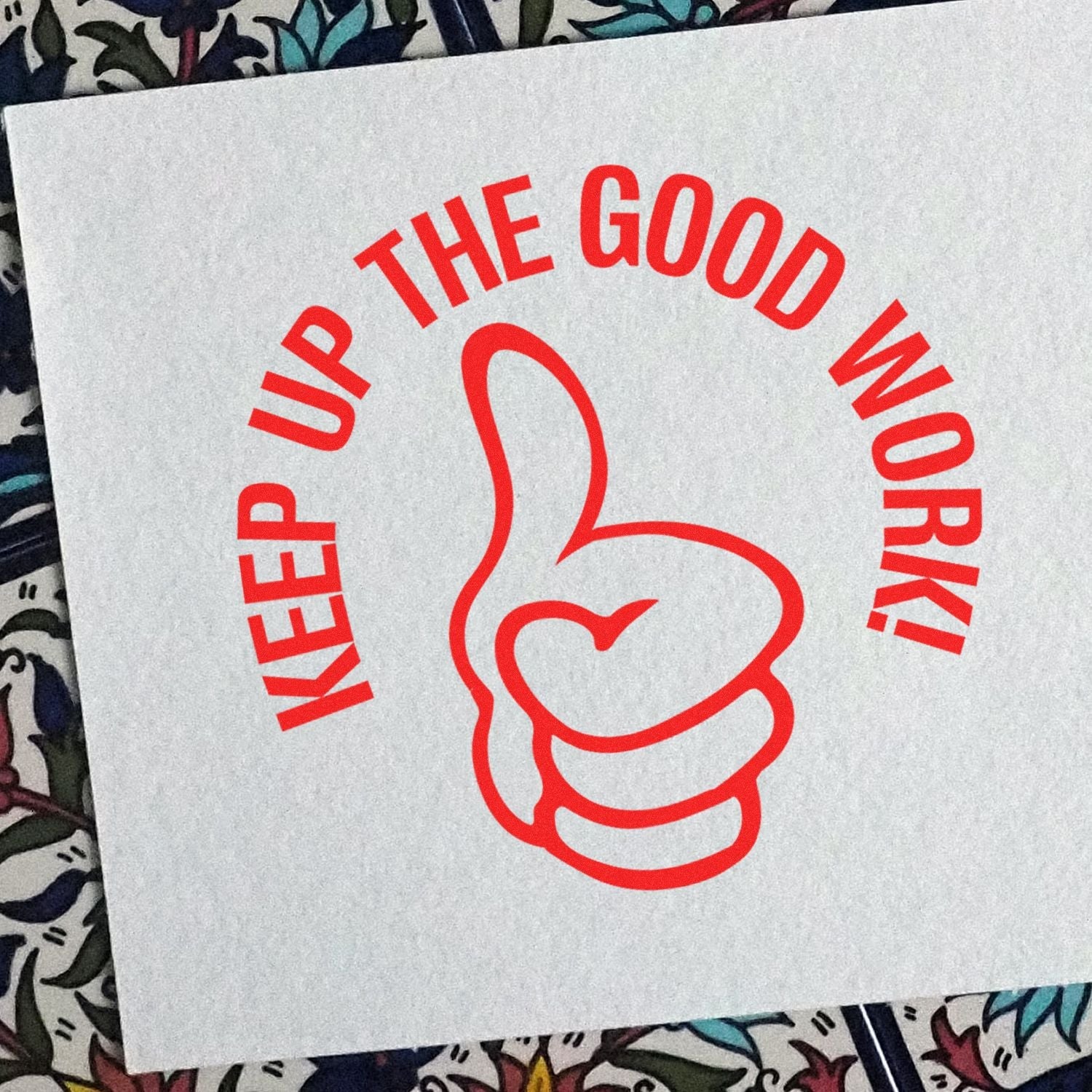 Self Inking Round Keep up the Good Work Stamp imprint on paper, featuring a red thumbs-up graphic and the text KEEP UP THE GOOD WORK!