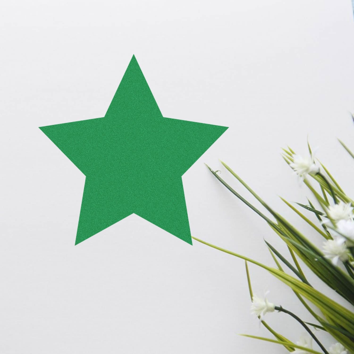 Self Inking Round Solid Star Stamp in use, creating a green star on white paper, with green plants in the background.