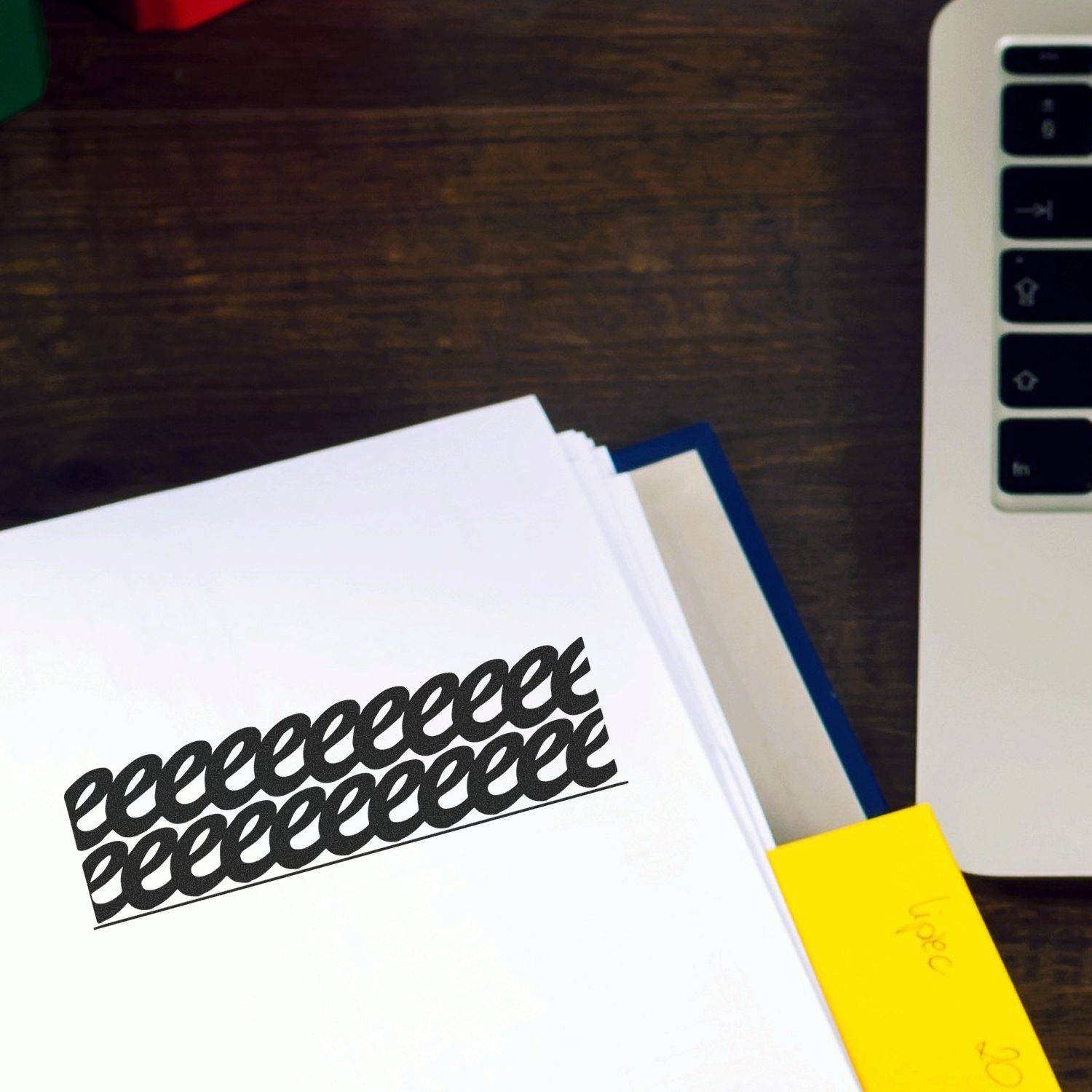 Large Pre-Inked Strikeout Stamp in use, striking out text on a document placed on a wooden desk next to a laptop and sticky notes.