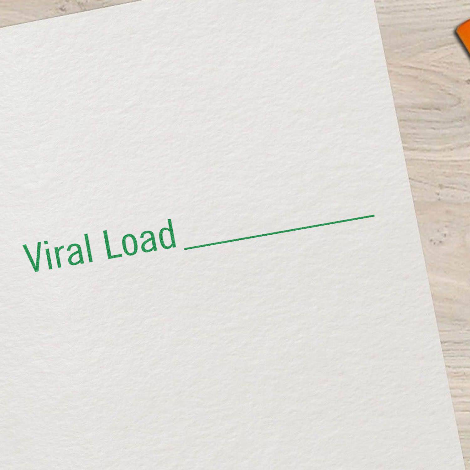 Large Pre-Inked Viral Load Stamp imprinting Viral Load on white paper, with a wooden surface in the background.