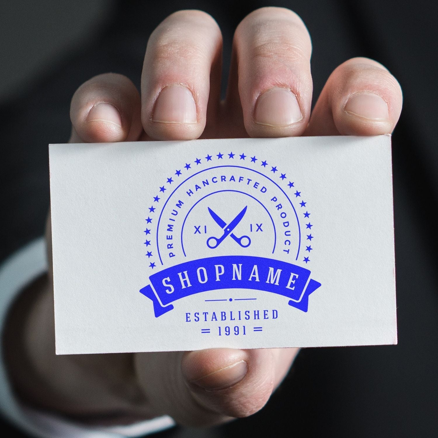 Hand holding a business card stamped with SHOPNAME using a Custom Rubber Stamp Size 3-1/2 Inch Diameter, featuring a blue design.
