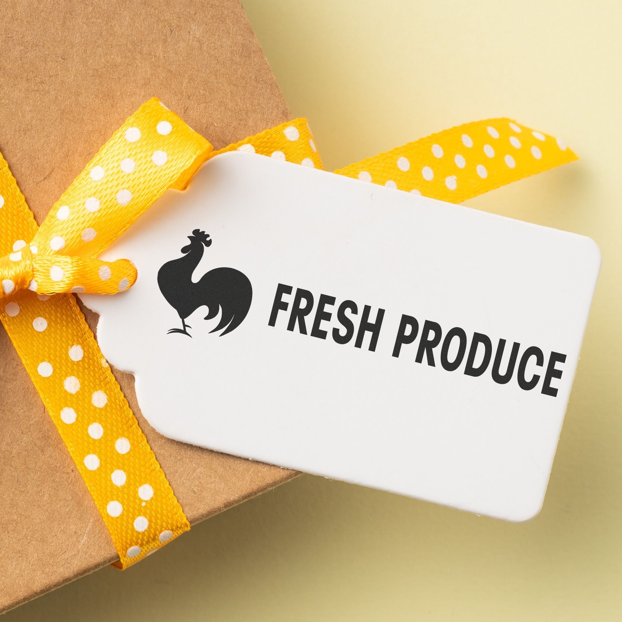 A gift tag stamped with FRESH PRODUCE using the Custom Self Inking Stamp Trodat 4913 Size 7/8 x 2-3/8, tied with a yellow polka dot ribbon.