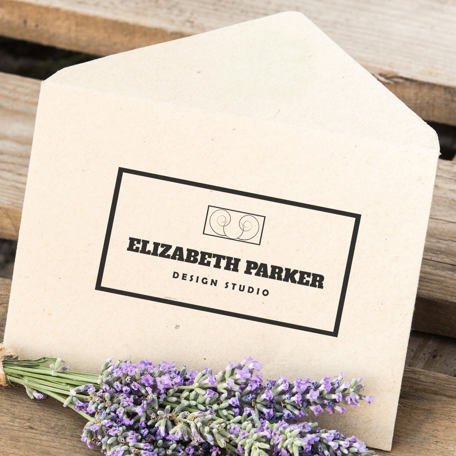 Envelope stamped with Custom Self Inking Stamp Trodat 5211 Size 2-5/32 x 3-5/16, next to a bundle of lavender flowers on a wooden surface.