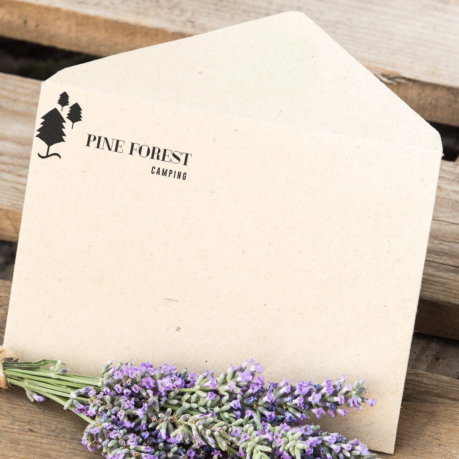 Envelope stamped with Pine Forest Camping using Slim Stamp 2264 Customized Pre-Inked Stamp 13/16 x 2-1/2, placed on wooden surface with lavender.