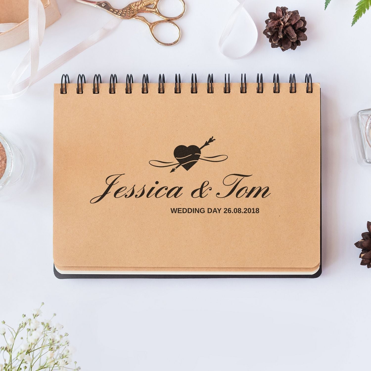 Custom Rubber Stamp Size 3 x 6 used on a spiral notebook with Jessica & Tom and Wedding Day 26.08.2018 text, surrounded by craft supplies.