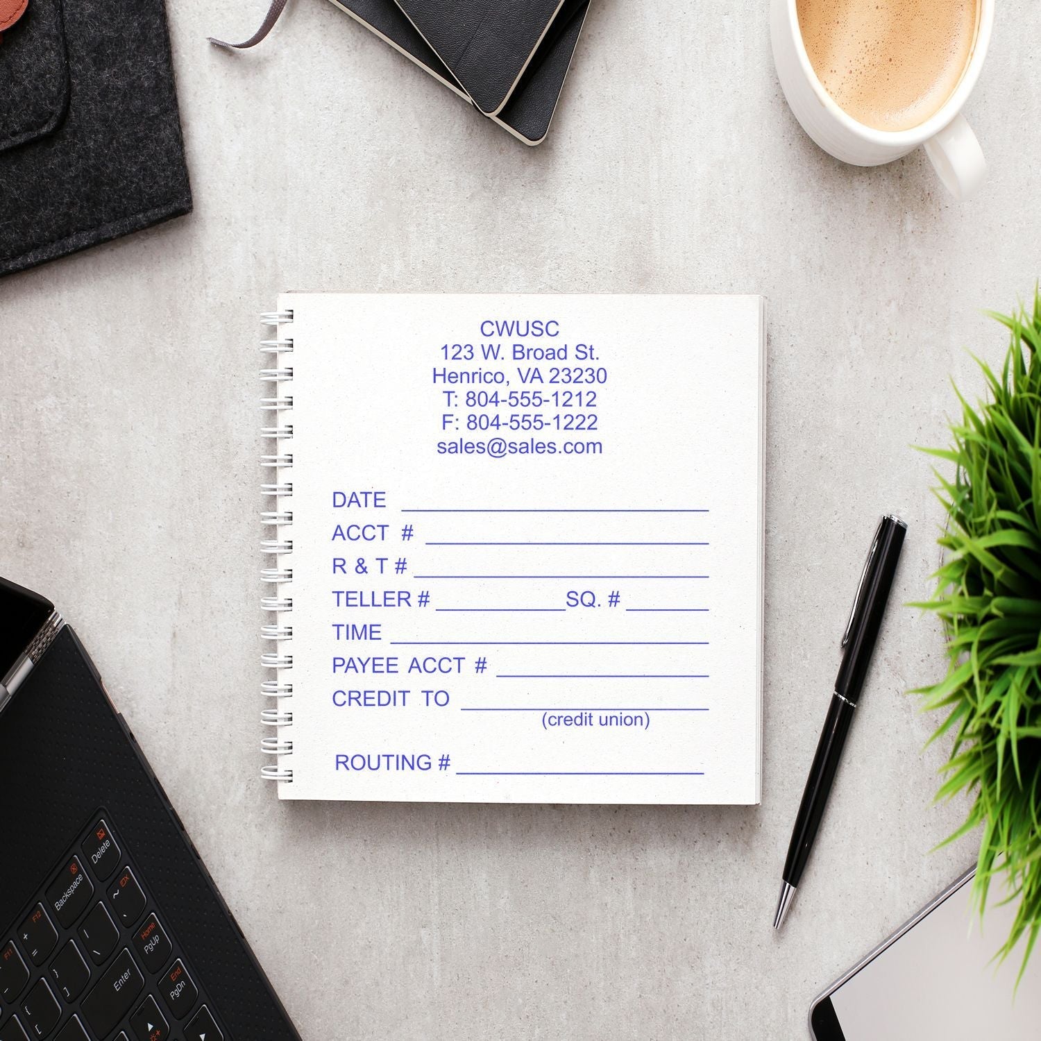 14 Line Custom Rubber Stamp with Wood Handle in use on a notebook, surrounded by office supplies, a laptop, and a cup of coffee.