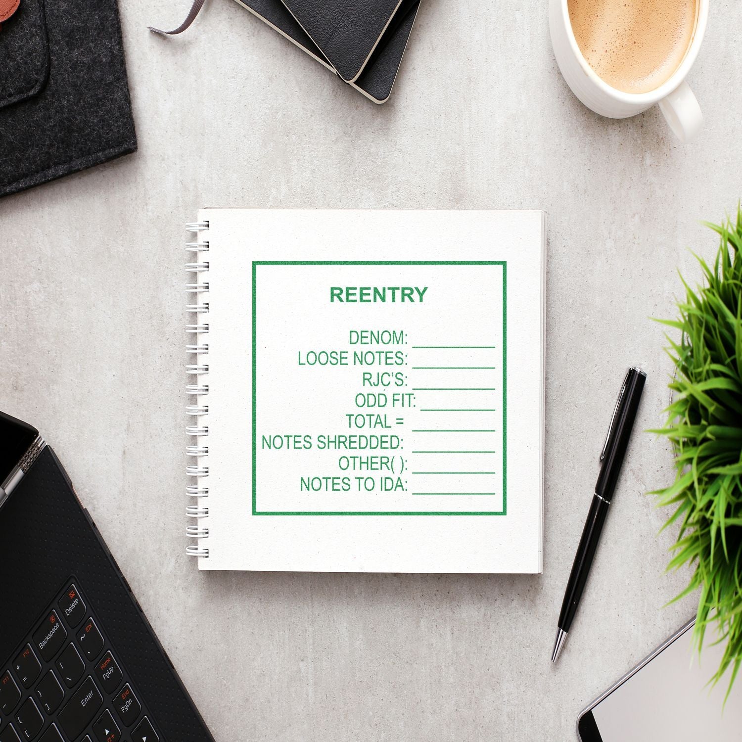 A 9 Line Custom Rubber Stamp with Wood Handle is used on a notebook, surrounded by a laptop, pen, coffee cup, and a plant.