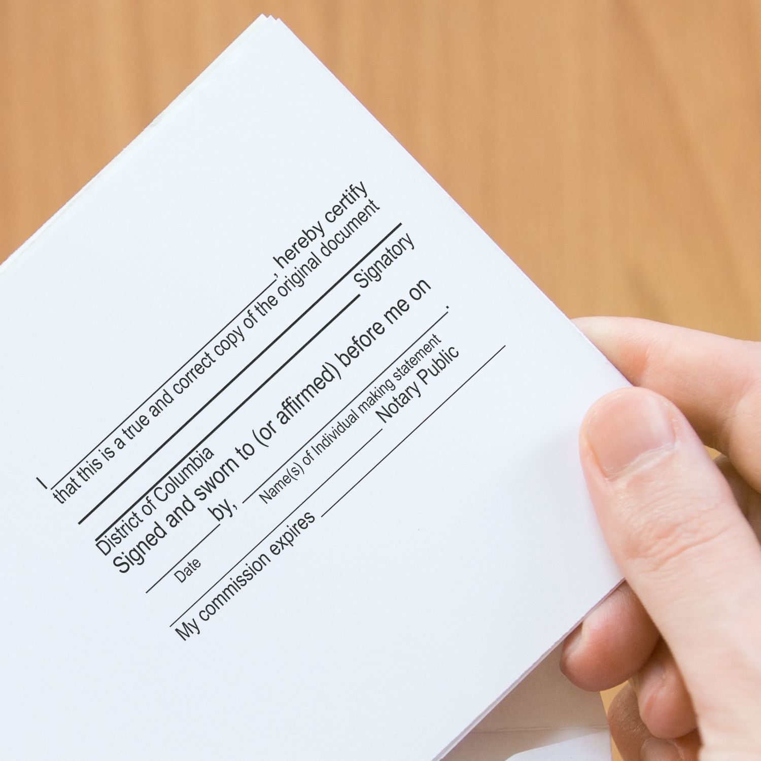 A hand holding a document stamped with a 13 Line Custom Rubber Stamp with Wood Handle, showing a notary public template.
