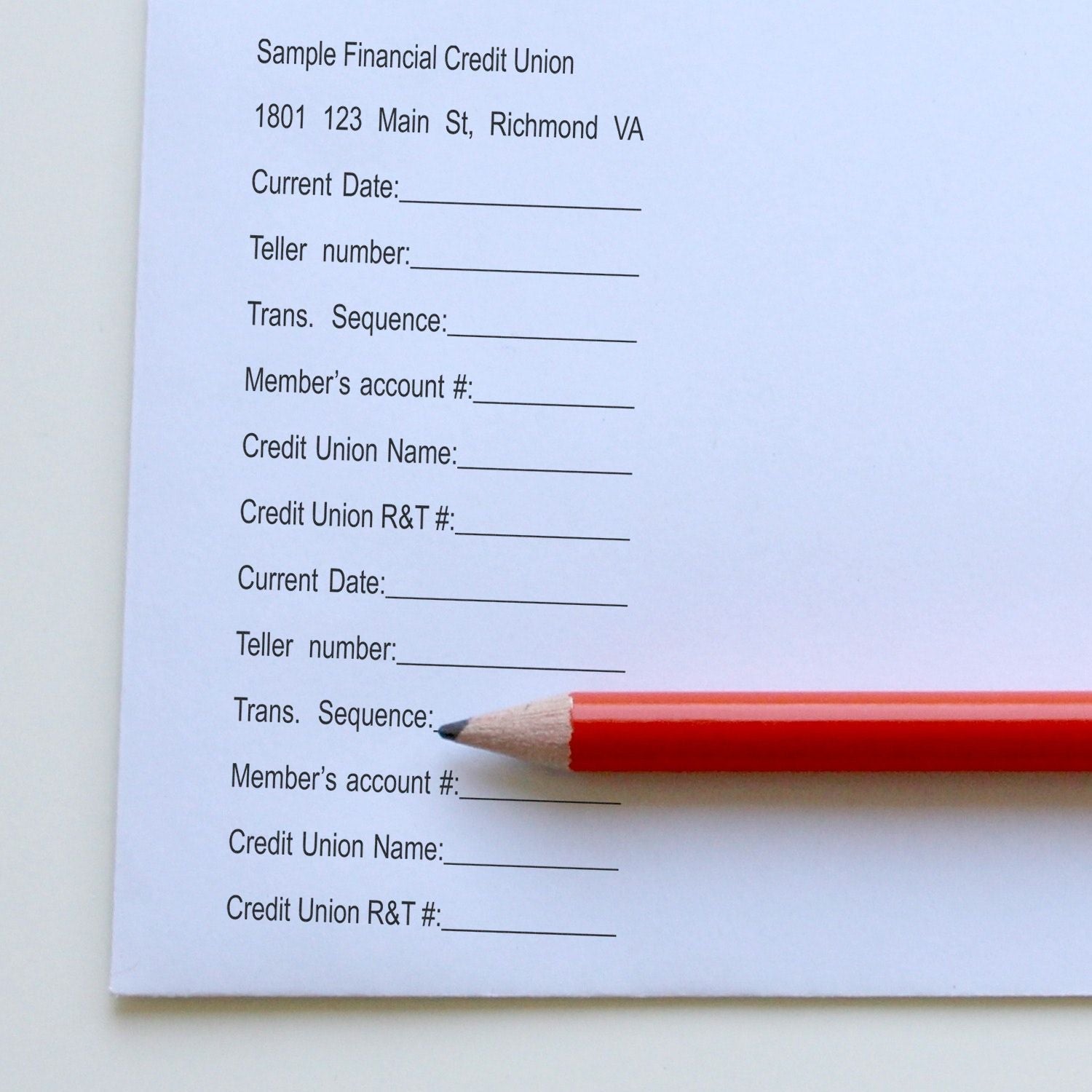 A red pencil rests on a paper stamped with a 12 Line Custom Rubber Stamp with Wood Handle, showing various financial form fields.