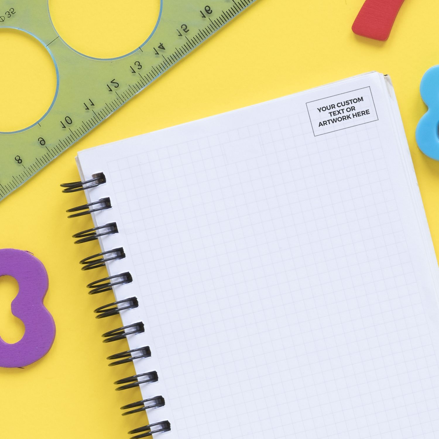 MaxLight XL2-125 Custom Pre-Inked Business Stamp 1 x 2 on a yellow background with a notebook, ruler, and colorful shapes.