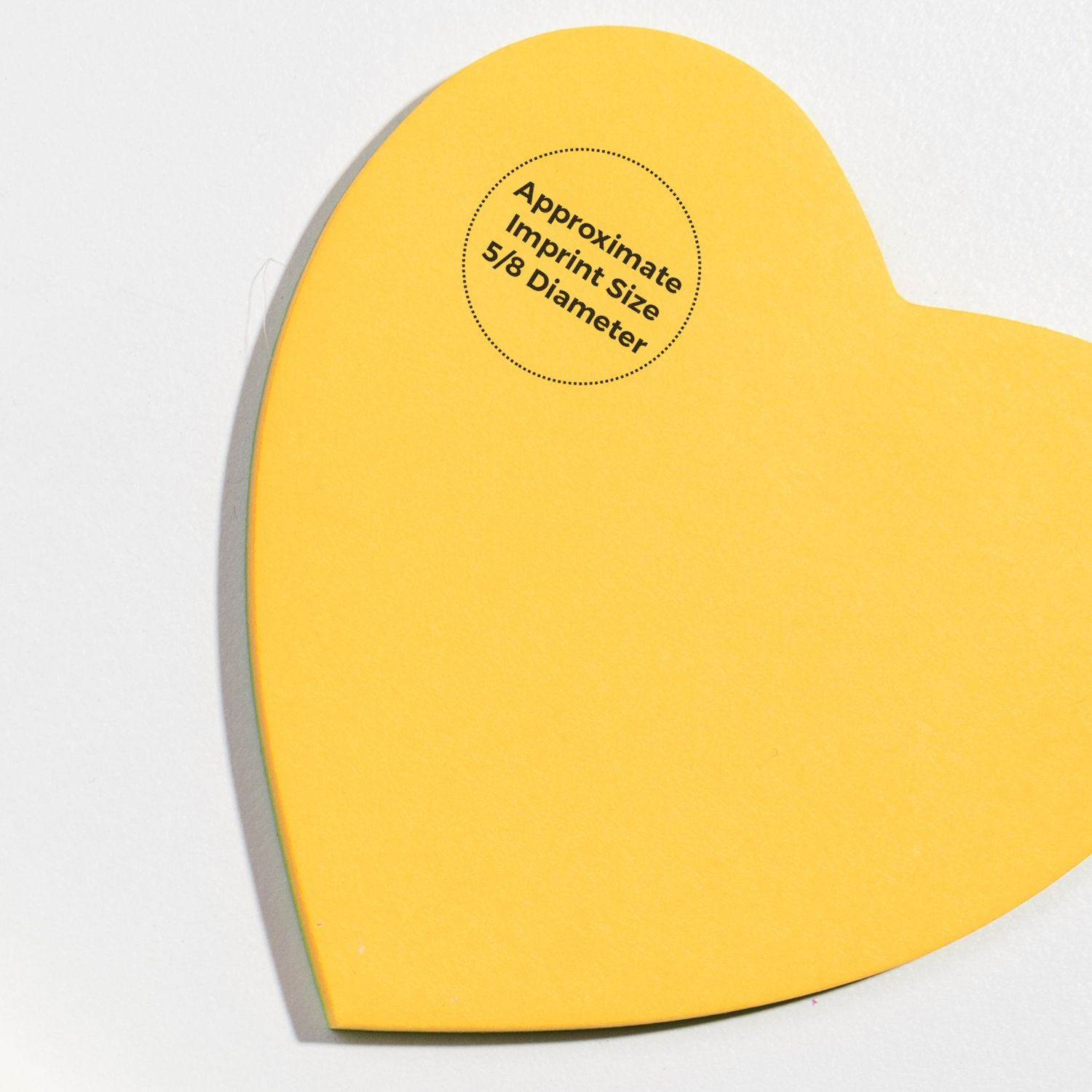 Yellow heart-shaped paper with text Approximate Imprint Size 5/8 Diameter showcasing MaxLight XL2-325 Custom Pre-Inked Business Stamp.
