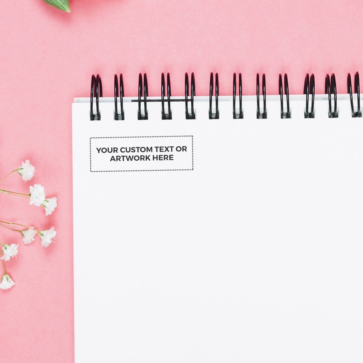 MaxLight XL2-75 Custom Pre-Inked Business Stamp 1/2 x 1-11/16 on a white notepad with flowers on a pink background.