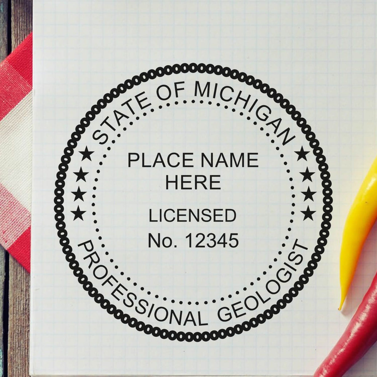 An in use photo of the Self-Inking Michigan Geologist Stamp showing a sample imprint on a cardstock