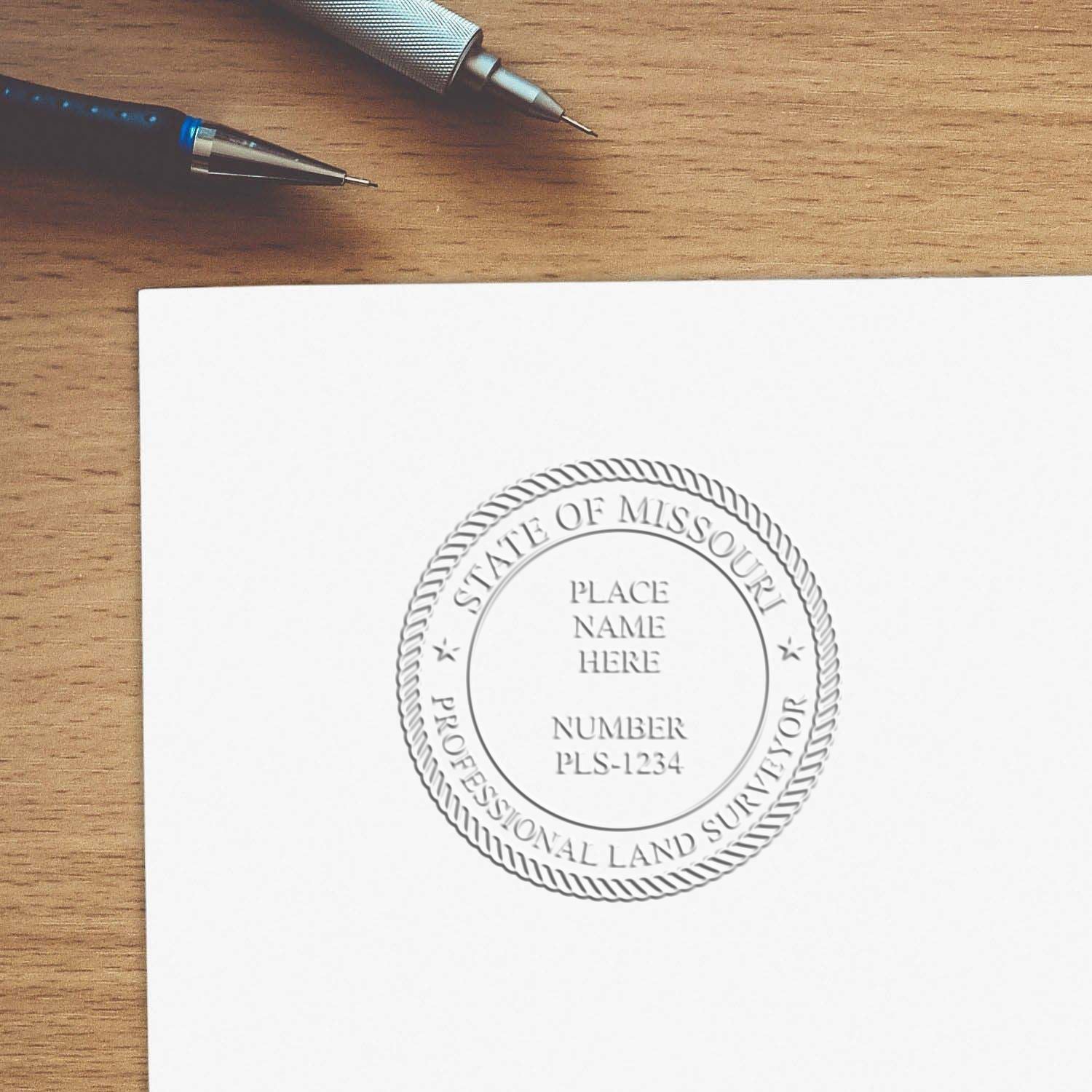A lifestyle photo showing a stamped image of the Extended Long Reach Missouri Surveyor Embosser on a piece of paper