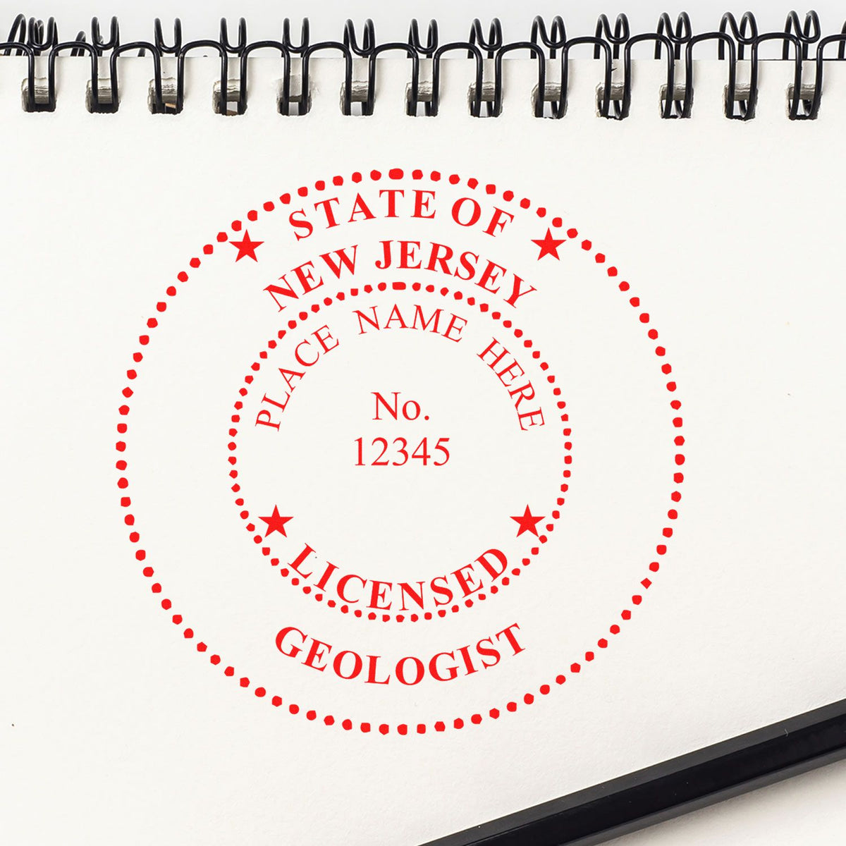 An in use photo of the Slim Pre-Inked New Jersey Professional Geologist Seal Stamp showing a sample imprint on a cardstock