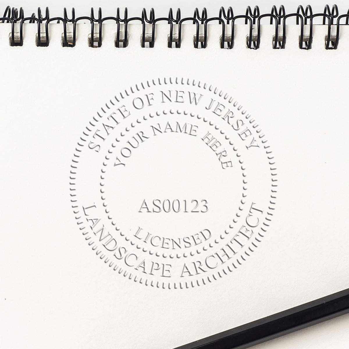 An in use photo of the Hybrid New Jersey Landscape Architect Seal showing a sample imprint on a cardstock