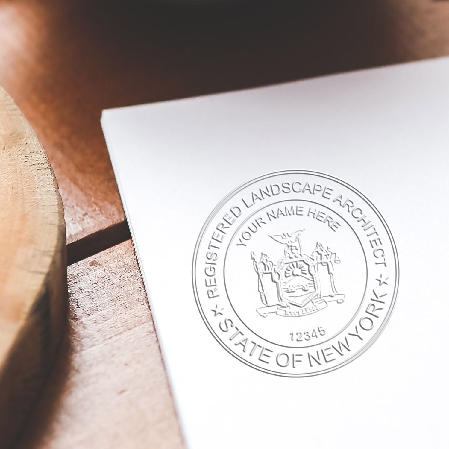 A lifestyle photo showing a stamped image of the Soft Pocket New York Landscape Architect Embosser on a piece of paper