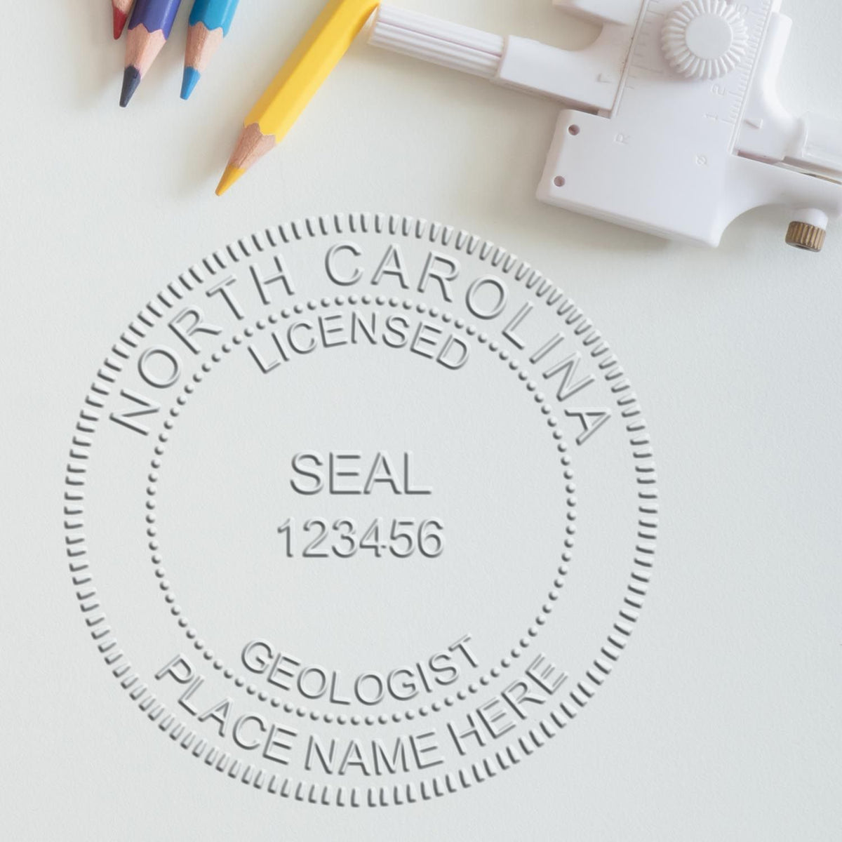 A lifestyle photo showing a stamped image of the Handheld North Carolina Professional Geologist Embosser on a piece of paper