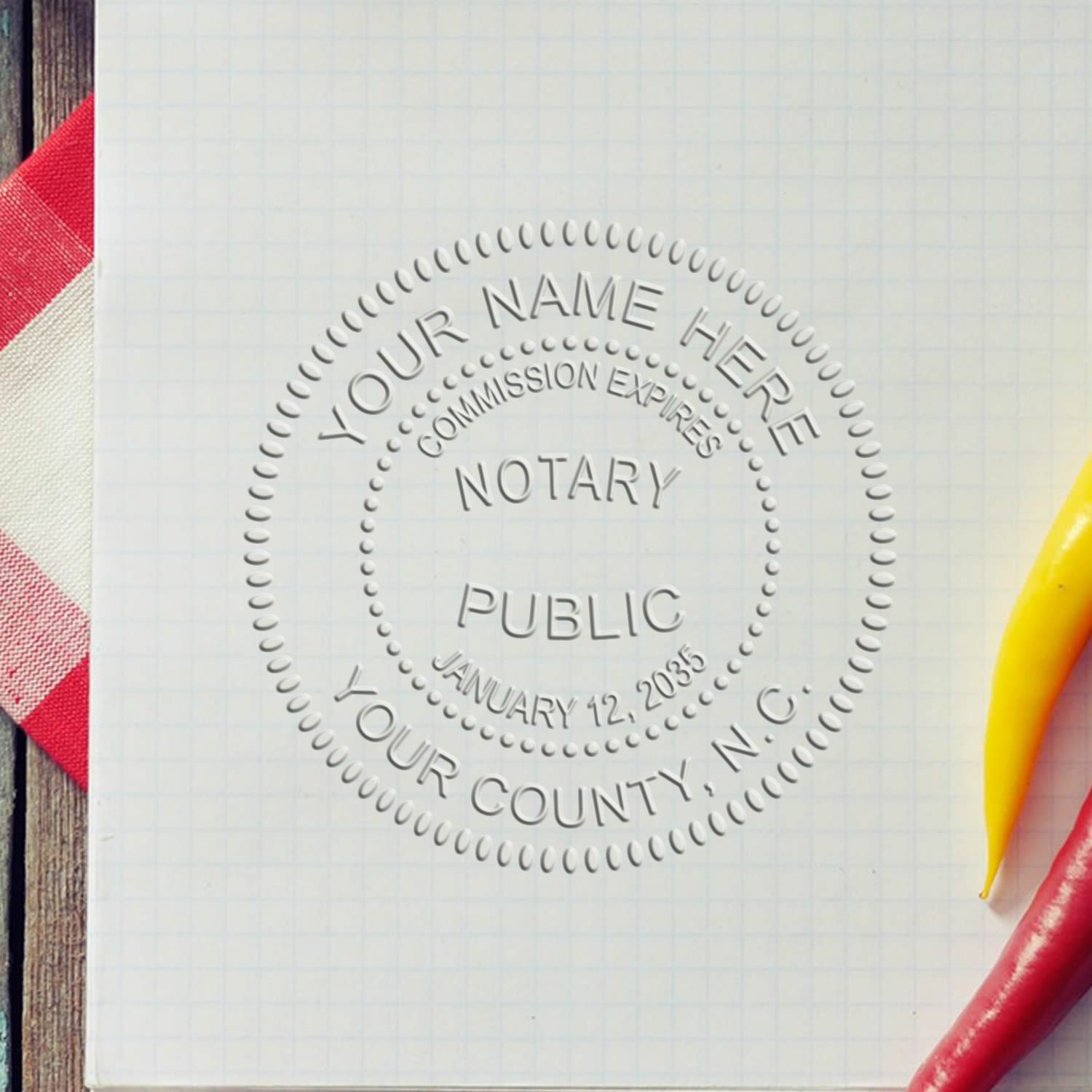 A stamped impression of the North Carolina Handheld Notary Seal Embosser in this stylish lifestyle photo, setting the tone for a unique and personalized product.