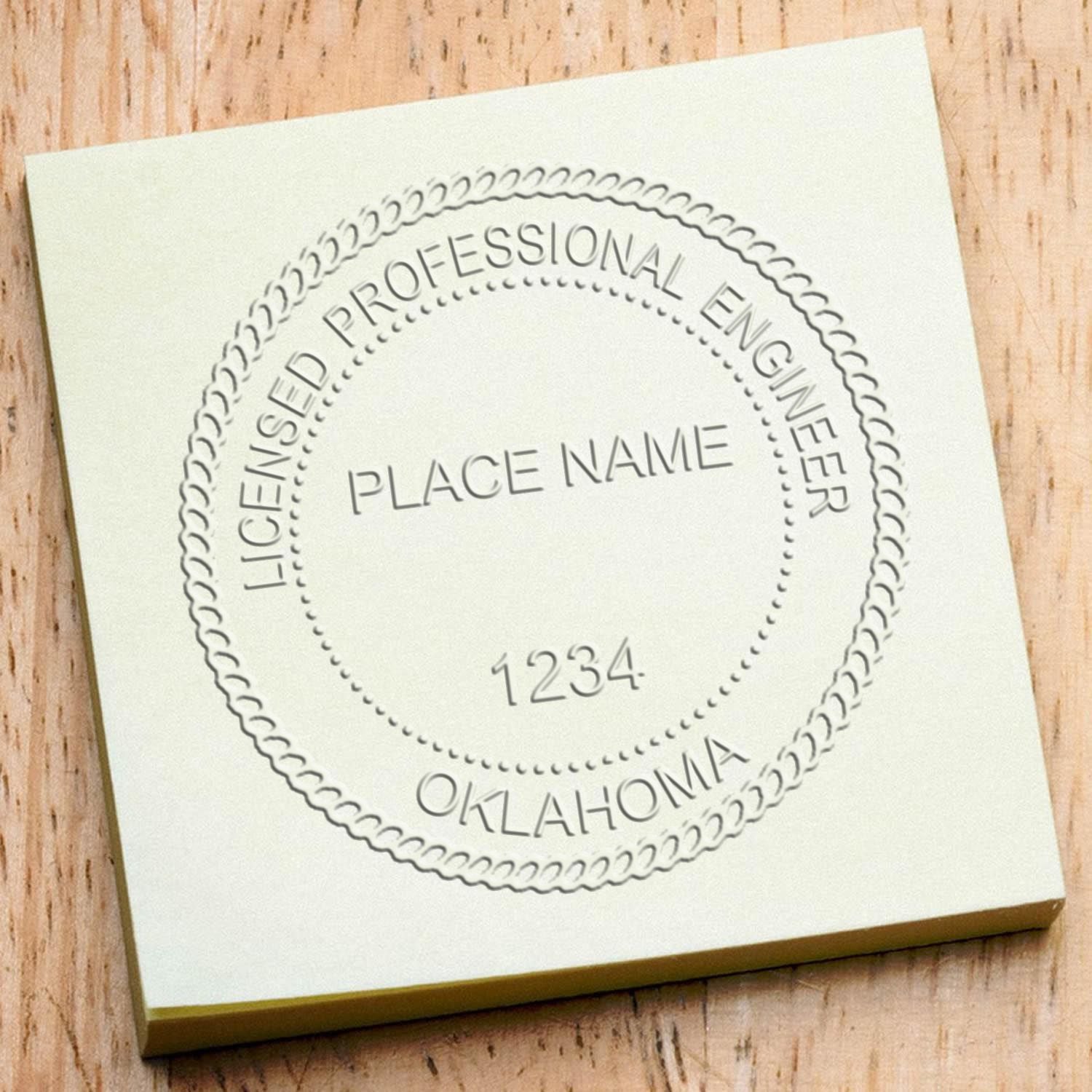 A lifestyle photo showing a stamped image of the Handheld Oklahoma Professional Engineer Embosser on a piece of paper