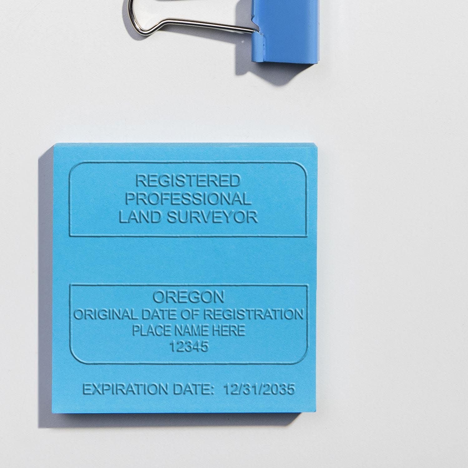 A lifestyle photo showing a stamped image of the Extended Long Reach Oregon Surveyor Embosser on a piece of paper
