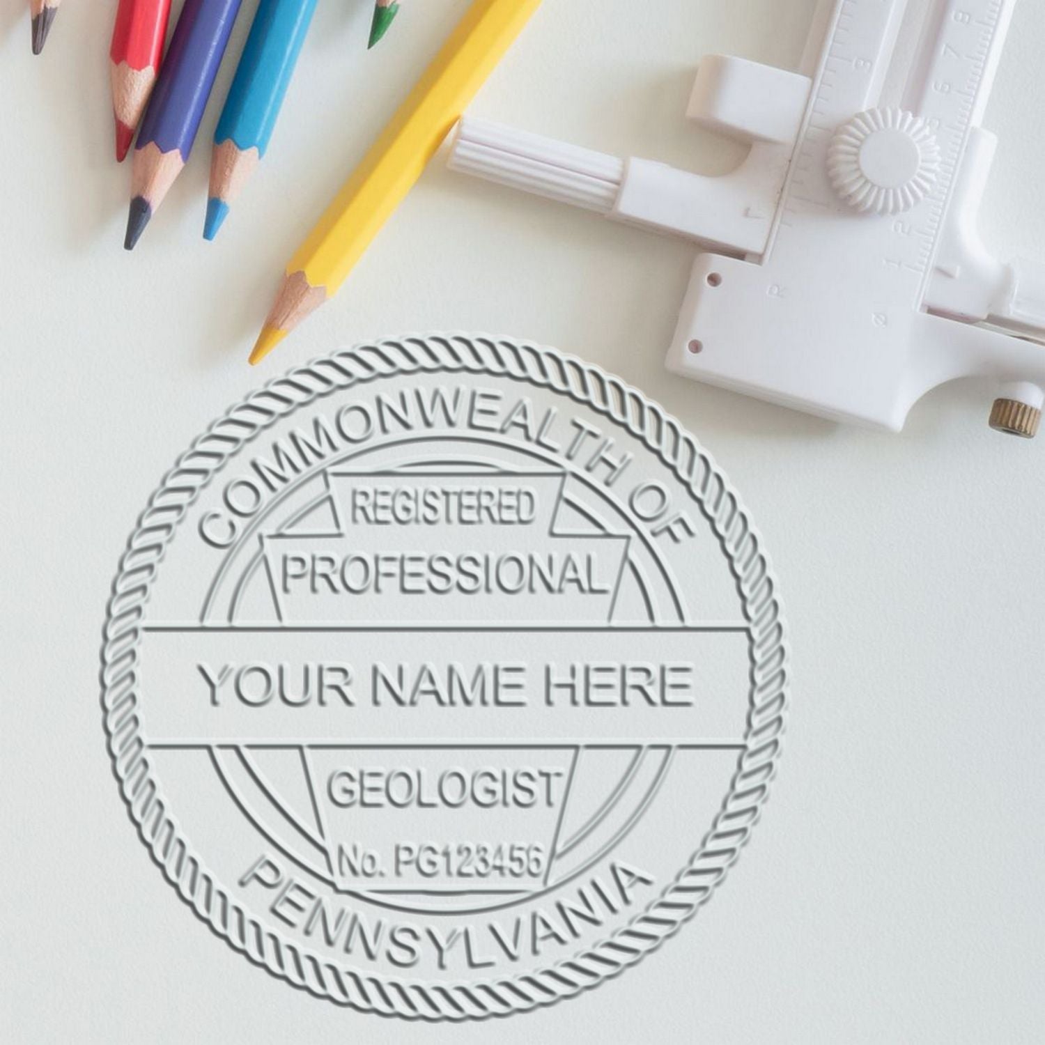 A lifestyle photo showing a stamped image of the Heavy Duty Cast Iron Pennsylvania Geologist Seal Embosser on a piece of paper