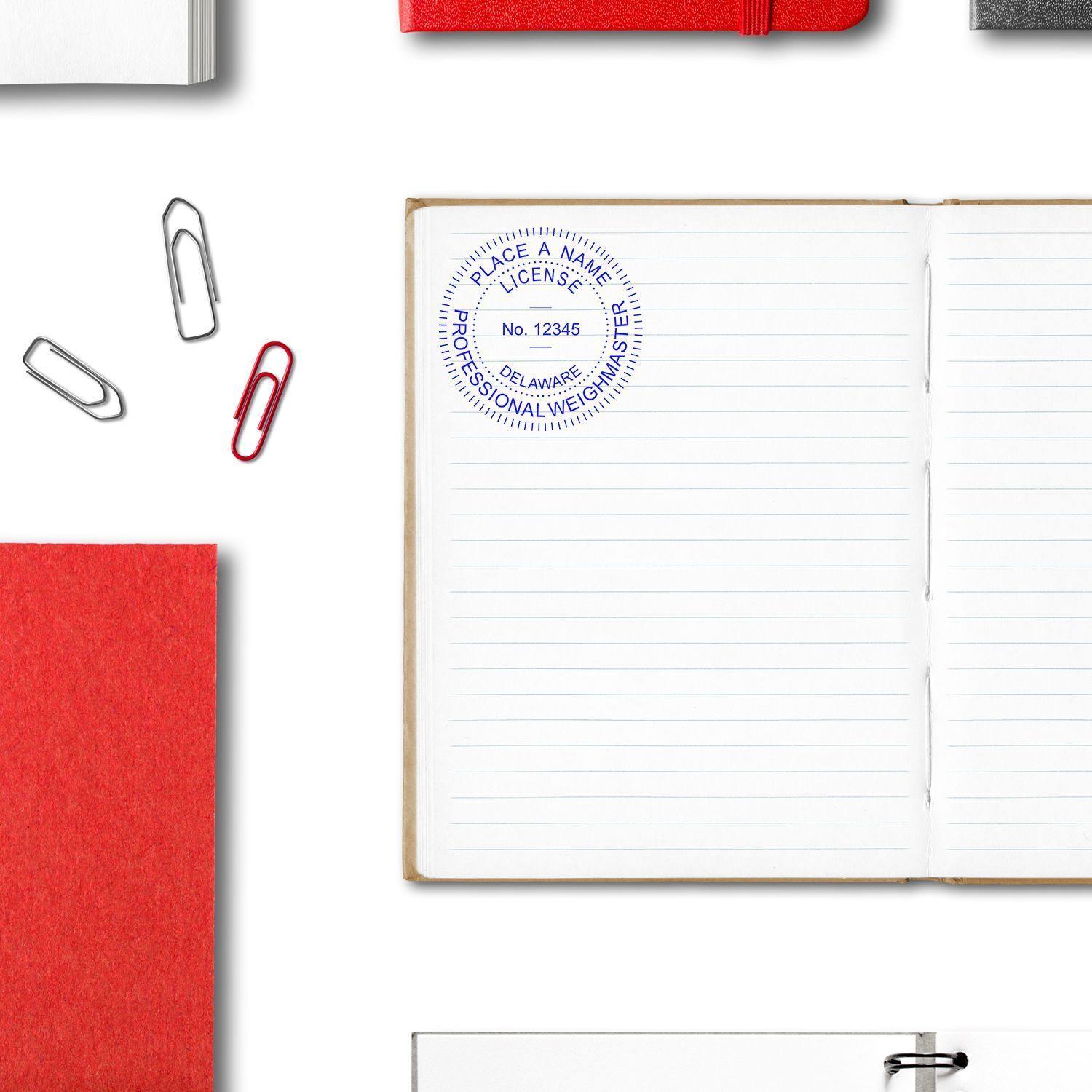 Public Weighmaster Slim Pre-Inked Rubber Stamp of Seal stamped on an open notebook, surrounded by paper clips and red notebooks.