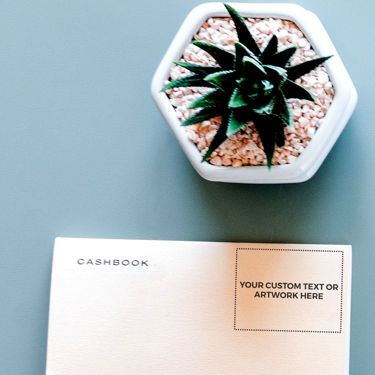 Custom Rubber Stamp Size 1-1/2 x 2 used on a cashbook page, with a potted succulent plant in the background.