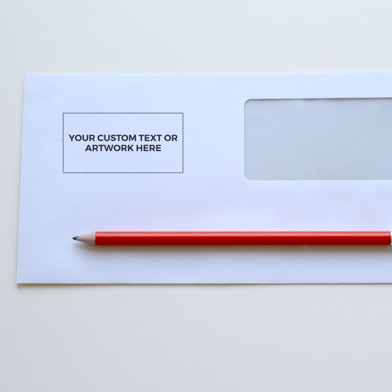 Envelope stamped with YOUR CUSTOM TEXT OR ARTWORK HERE using Custom Rubber Stamp Size 1-1/2 x 3, with a red pencil beside it.