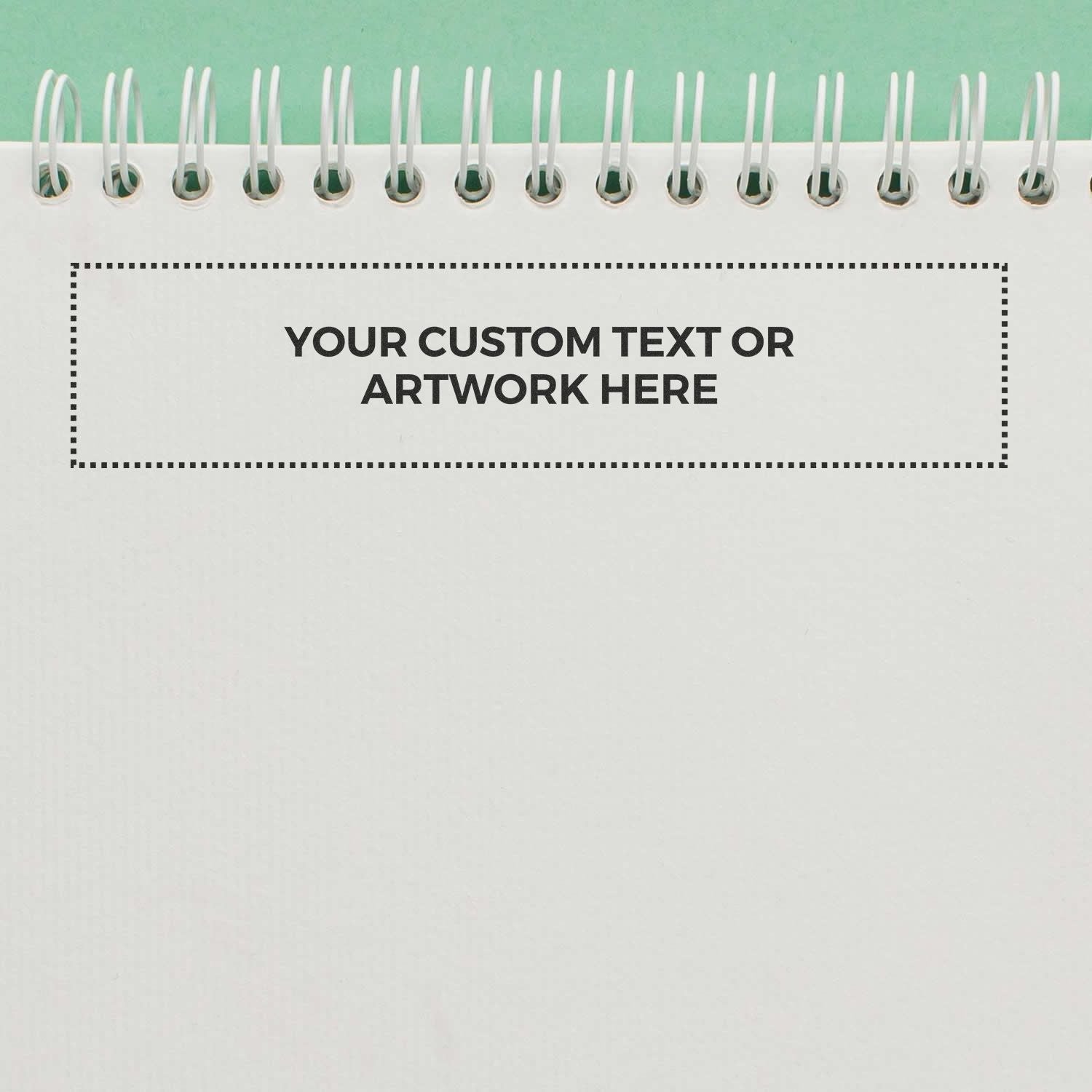 Custom Rubber Stamp Size 1-1/2 x 7 stamped on a white spiral notebook with the text YOUR CUSTOM TEXT OR ARTWORK HERE in black.