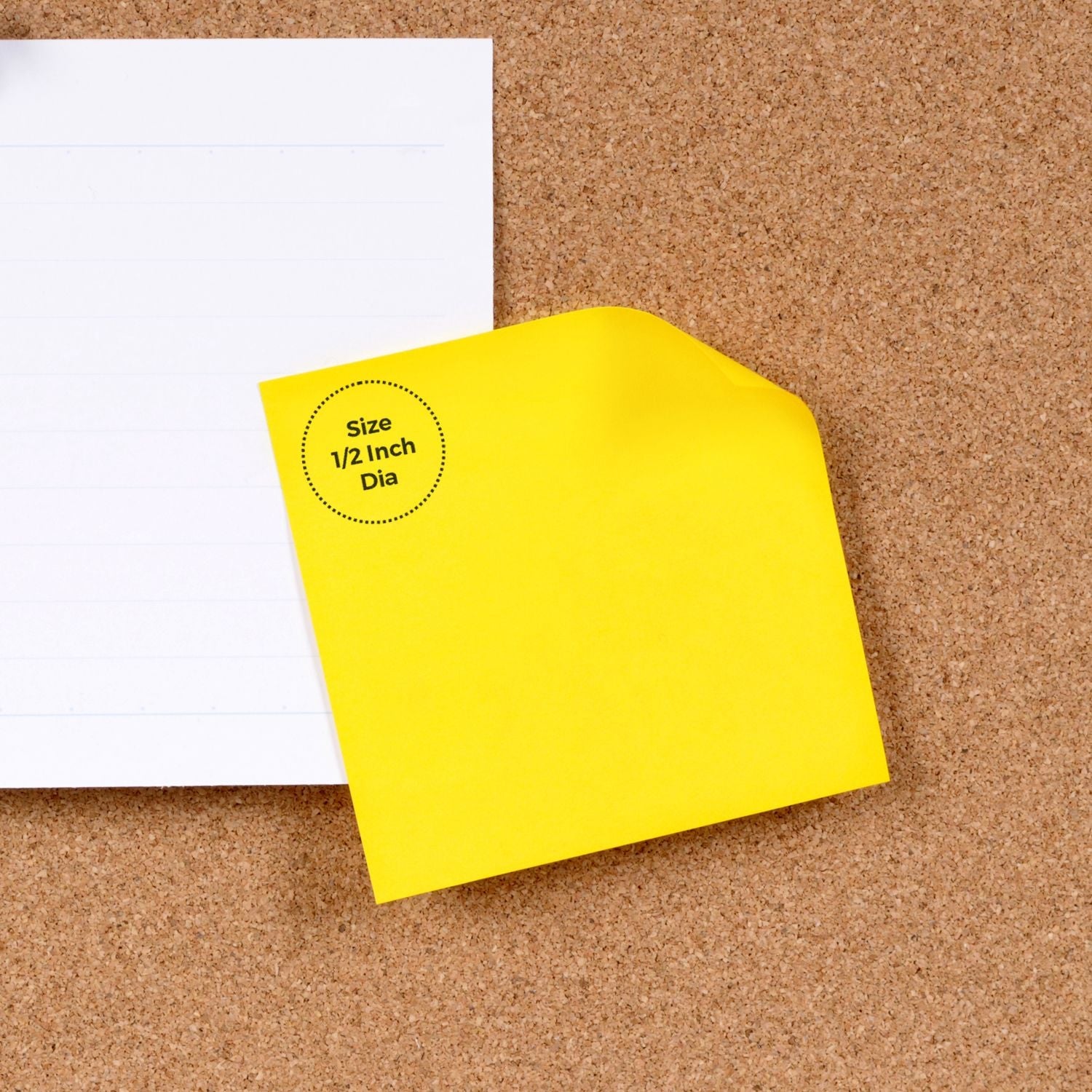 Custom Rubber Stamp Size 1/2 Inch Diameter shown on a yellow sticky note placed on a corkboard next to a white lined paper.