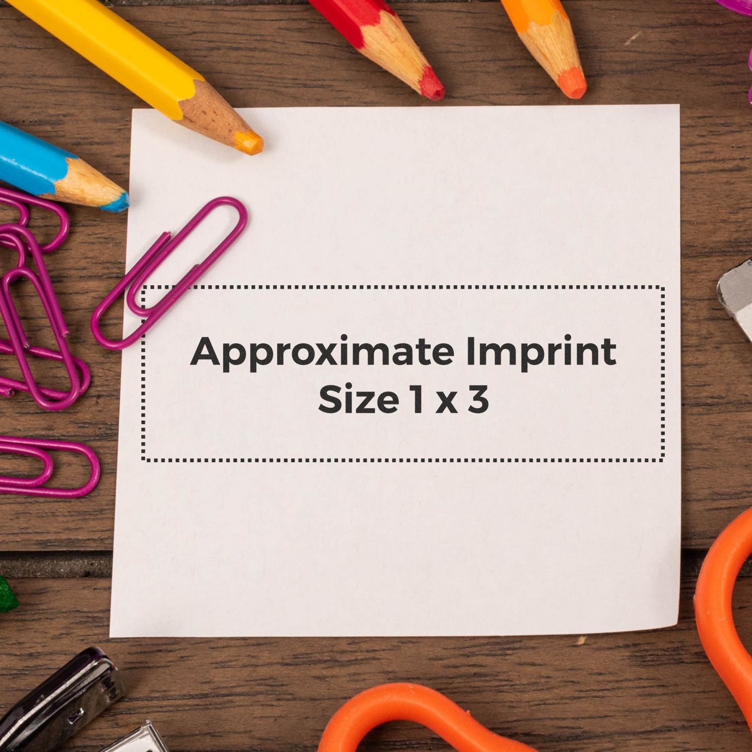 Custom Rubber Stamp Size 1 x 3 shown on a white paper with colorful pencils, paper clips, and a wooden background.