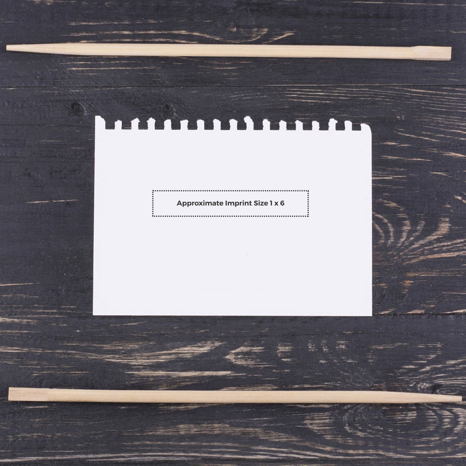 Custom Rubber Stamp Size 1 x 6 displayed on a white notepad with wooden sticks on a dark wooden surface.