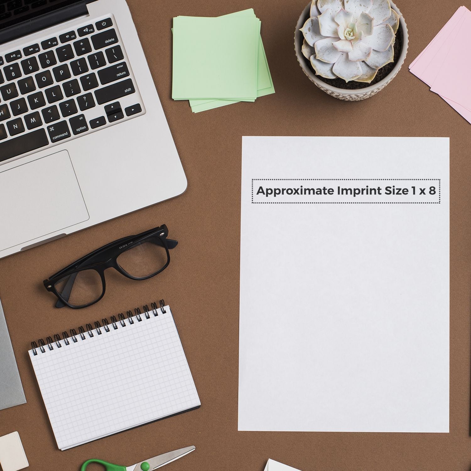 Custom Rubber Stamp Size 1 x 8 shown on a desk with a laptop, glasses, notepad, and a plant.