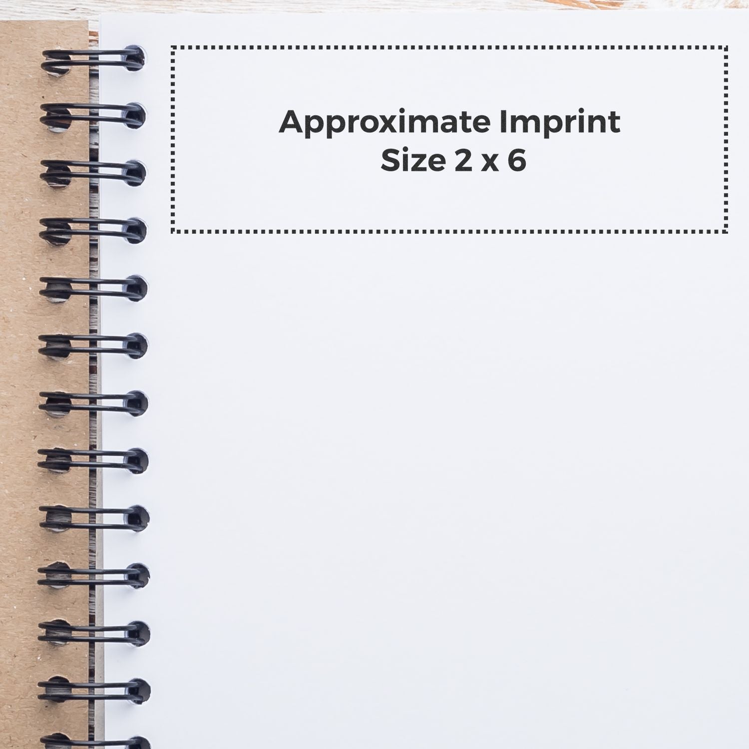 Custom Rubber Stamp Size 2 x 6 shown on a spiral notebook with dotted outline indicating the approximate imprint area.