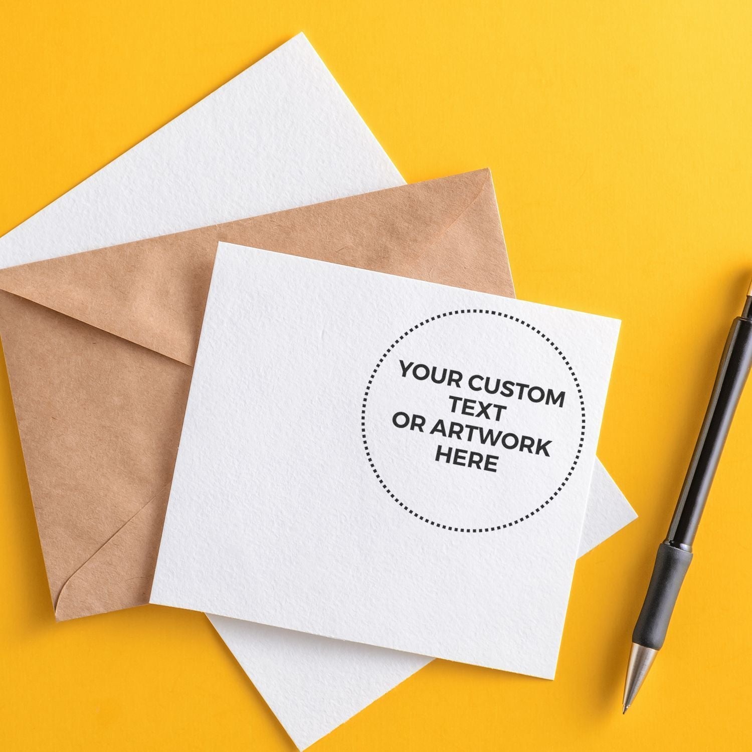 Custom Rubber Stamp Size 3 Inch Diameter used on a white card with Your Custom Text or Artwork Here next to a brown envelope and pen.