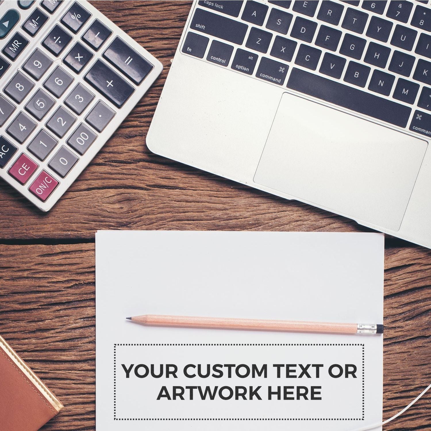 Custom Rubber Stamp Size 3 x 10 stamped on paper with YOUR CUSTOM TEXT OR ARTWORK HERE next to a pencil, laptop, and calculator.